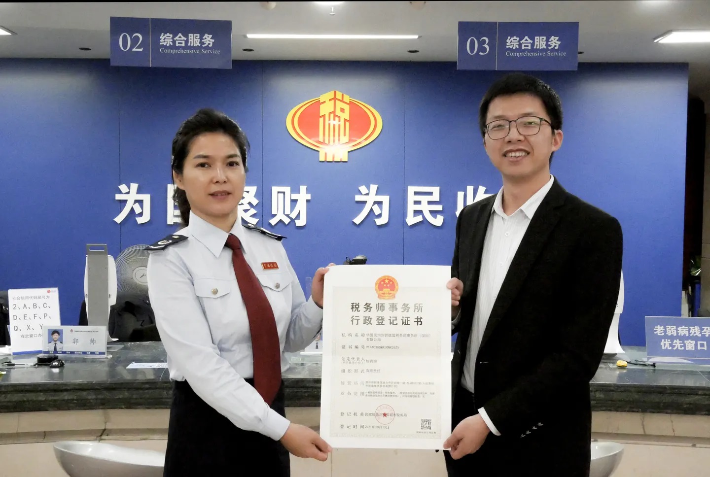 A representative of the HMLK Joint Venture Tax Agency collects the company's administrative registration certificate. Photo by Shenzhen Tax Service of State Taxation Administration.jpg